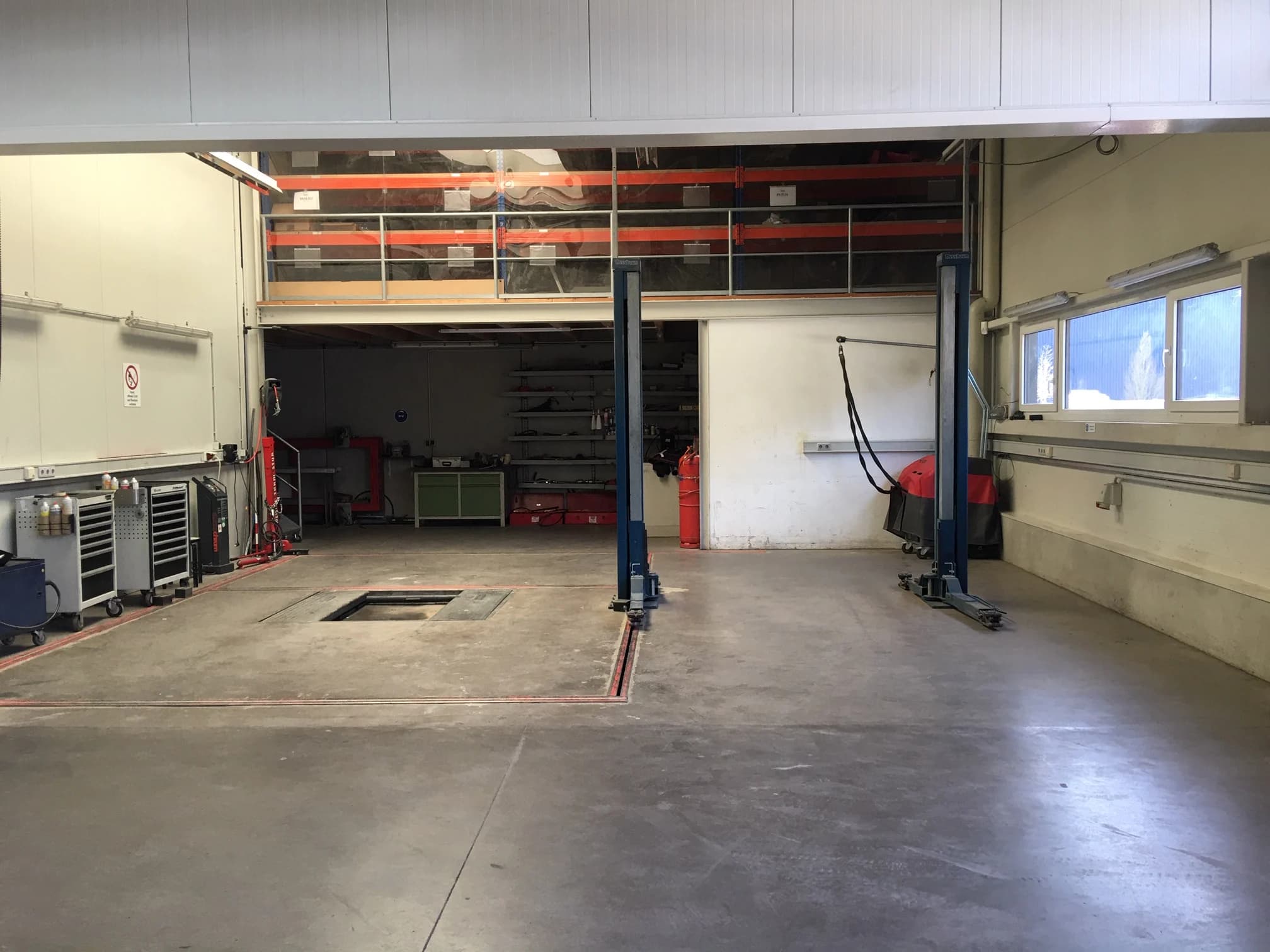 Blick durch die leere Werkstatthalle mit Hebebühne