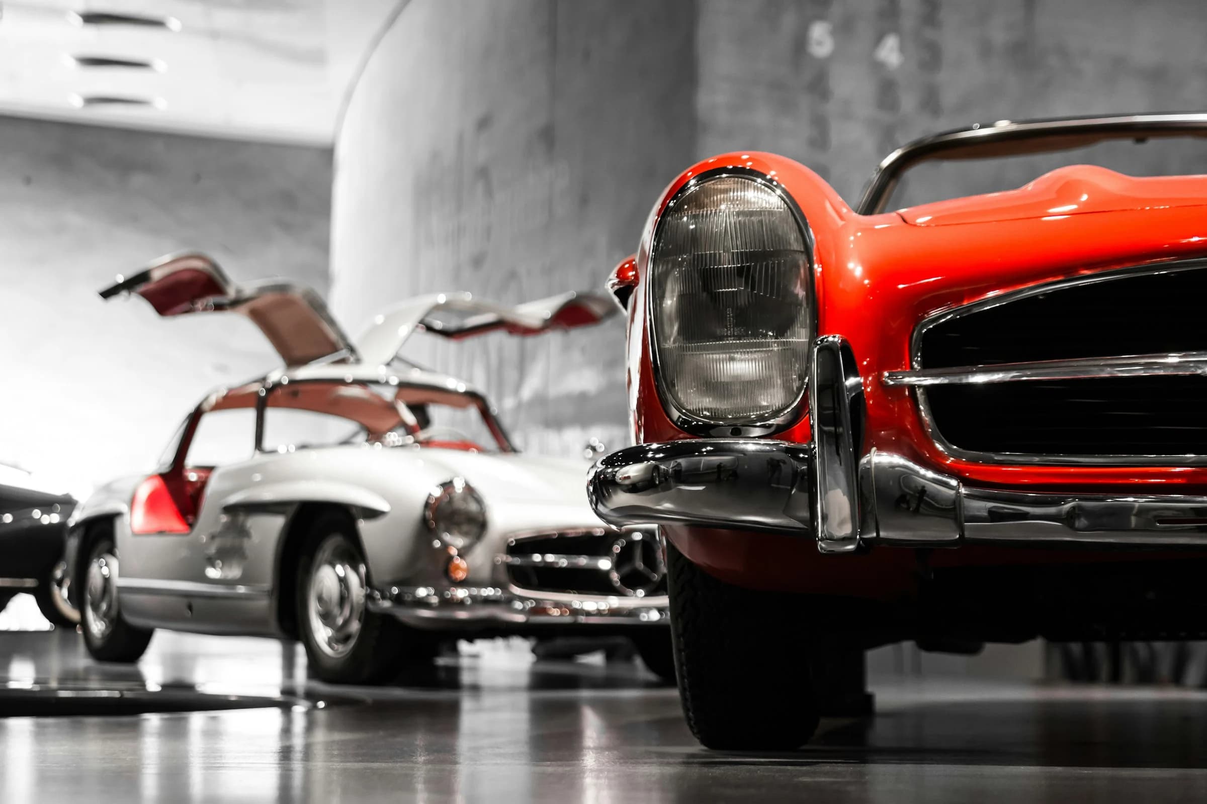 Klassische Mercedes-Sportwagen mit Flügeltüren und Chrom in einer hellen Ausstellungshalle (Symbolbild)