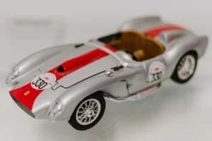 Modell eines silbernen historischen Rennwagens mit roten Streifen